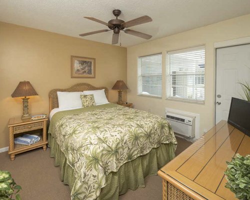 A well furnished bedroom with a queen bed and an outdoor view.