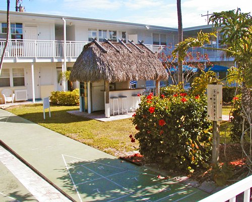 An outdoor picnic area with a bar and shuffle boards.