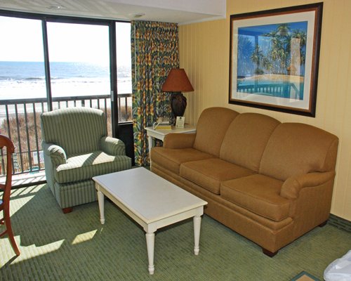 A well furnished living room with balcony and ocean view.