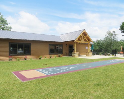 Exterior view of an Alpine Village building and play area with shuffle board.