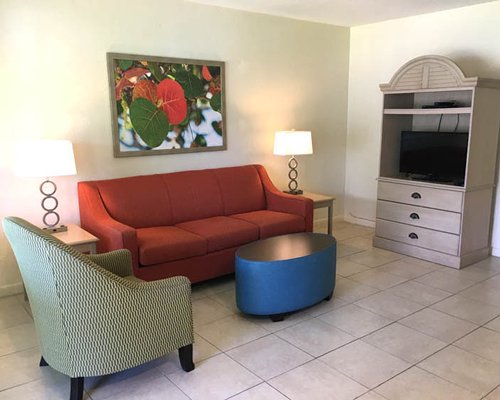 A well furnished living room with double pull out sofa and a television.