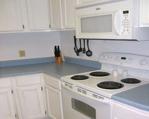 An open plan kitchen equipped with a stove and microwave.
