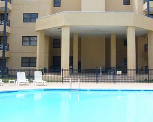 An outdoor swimming pool with multi story units.