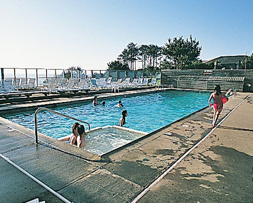 An outdoor swimming pool with chaise lounge chairs.