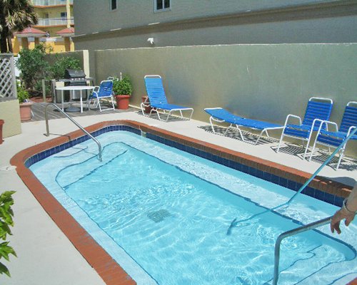 An outdoor swimming pool with chaise lounge chairs.