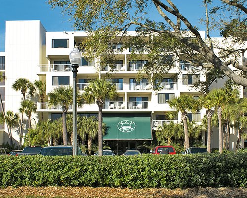 Scenic exterior view of multi story resort unit with private balconies and car parking.