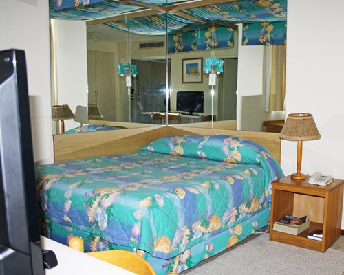 A well furnished bedroom with a double bed and television.