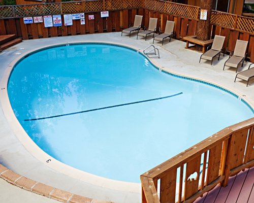 An outdoor swimming pool with chaise lounge chairs.