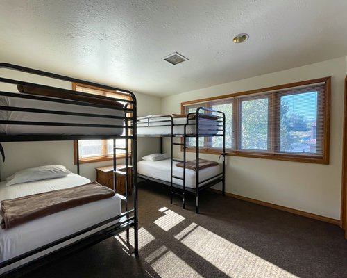 Furnished bed room with two bunk beds and outside view.