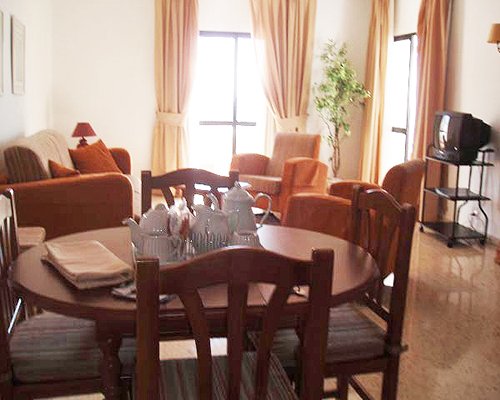 An open plan furnished living and dining area with a television.
