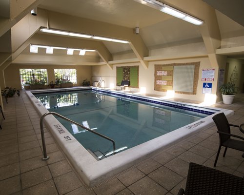 Indoor swimming pool with patio chairs.