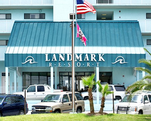 Exterior view of Landmark Holiday Beach Resort alongside parking.