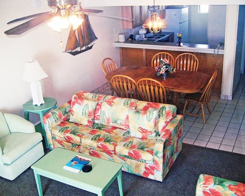 An open plan furnished living dining and kitchen area.
