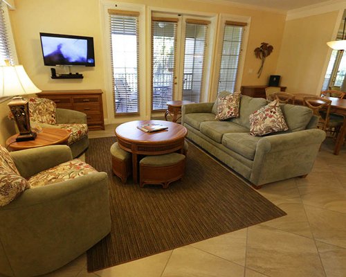 A well furnished living room with double pull out sofa and a television.