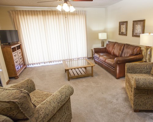 A well furnished living room with double pull out sofa and a television.