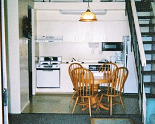 A well equipped kitchen with dining area alongside the staircase.