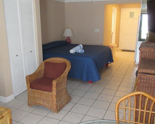 An open plan living and bedroom with a queen bed.