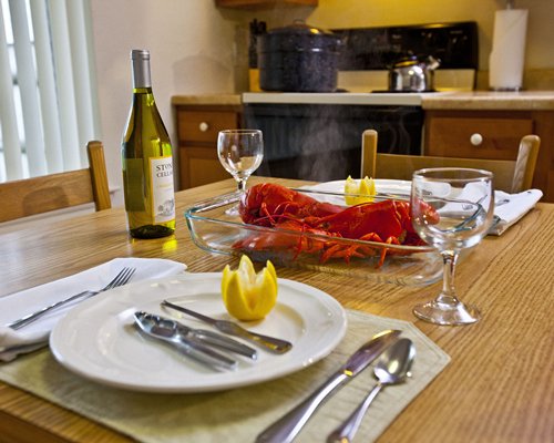 An open plan kitchen and dining area with lobster and champagne on the table.
