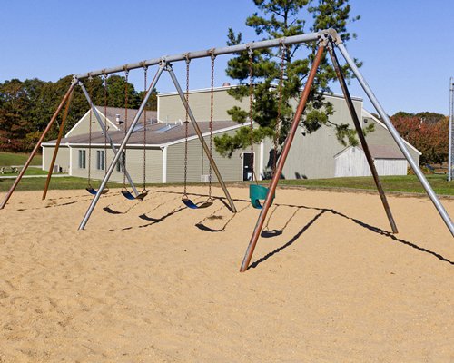 Swing in an outdoor playing area alongside resort.
