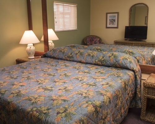 A well furnished bedroom with a king bed and a television.