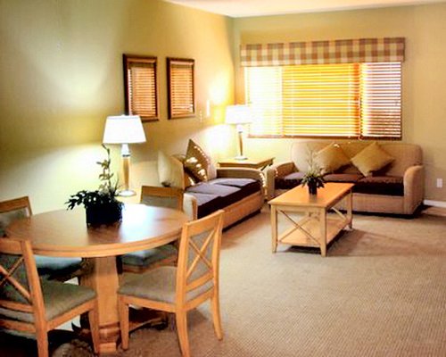 A well furnished living area alongside a dining table.