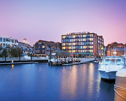 VIEW OF BUILDINGS ALONGSIDE OCEAN WITH BOATS.