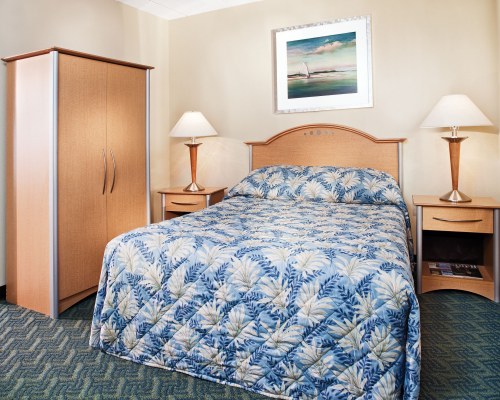 A WELL FURNISHED BEDROOM WITH A BED.
