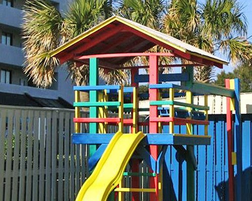 An outdoor play area alongside multi story resort units.