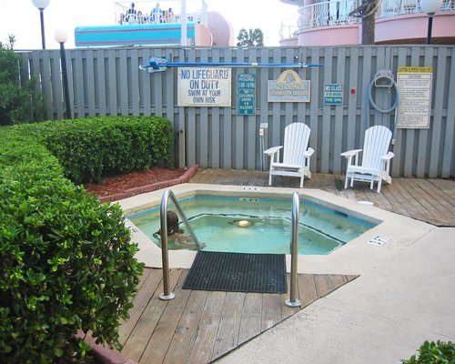 An outdoor hot tub with patio furniture.