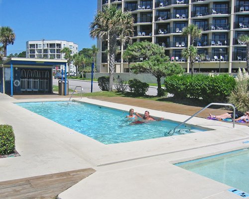 Scenic view of multiple unit balconies alongside outdoor swimming pool and hot tub.