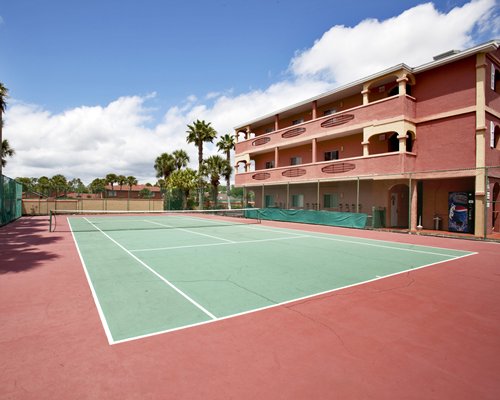 An outdoor tennis court alongside multi story units.