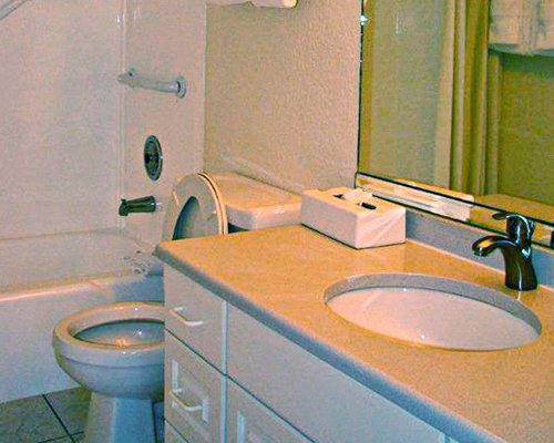 A bathroom with a bathtub and single sink vanity.