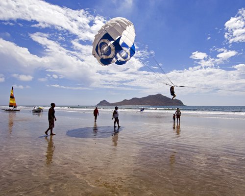 A scenic view of people paragliding alongside the beach.