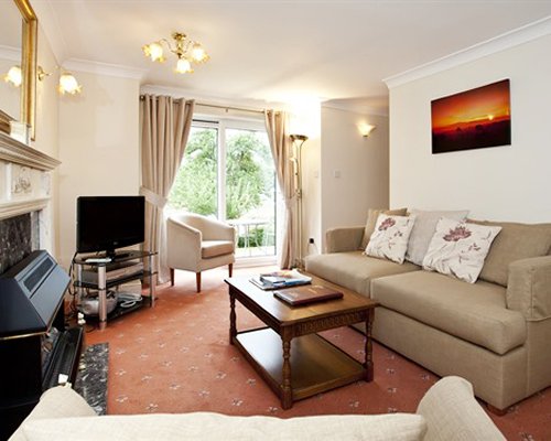 A well furnished living room with a fireplace and a television.