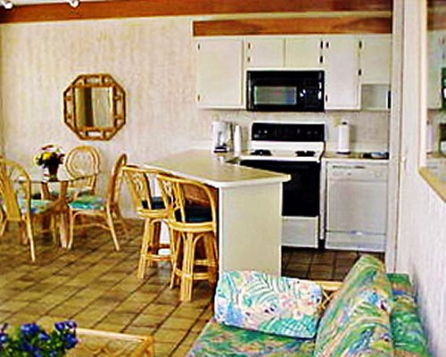 An open plan living kitchen and glass top dining area.