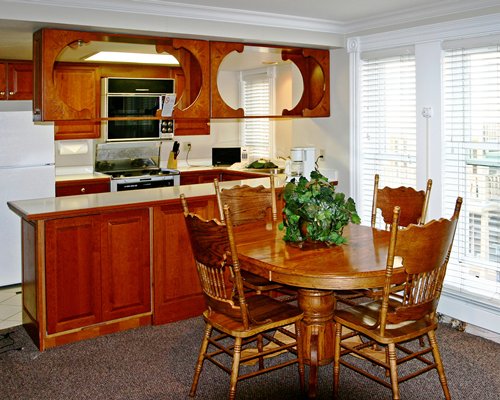 A well furnished dining area alongside a kitchen.