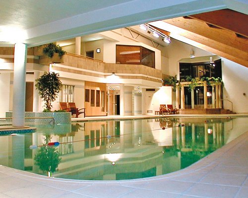 A large indoor swimming pool alongside a well furnished area.