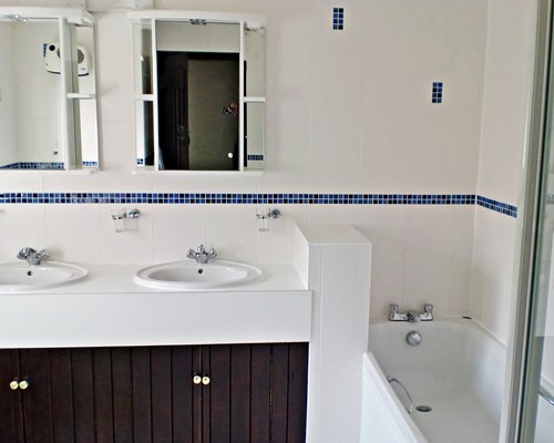 A bathroom with double sink vanity and a bathtub.