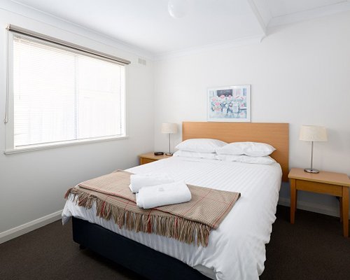 A well furnished bedroom with a queen bed and an outdoor view.
