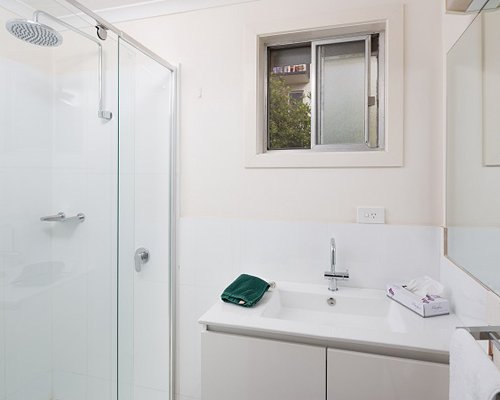 A bathroom with shower and sink vanity.