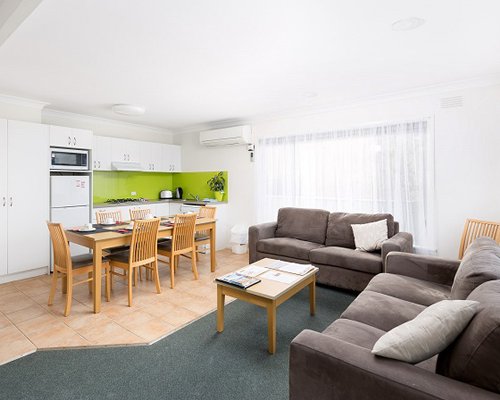 An open plan furnished living dining and kitchen area.