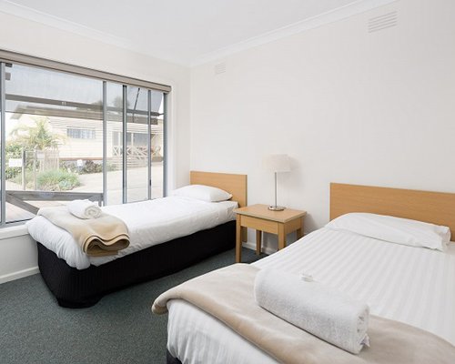 A well furnished bedroom with two twin beds and an outdoor view.