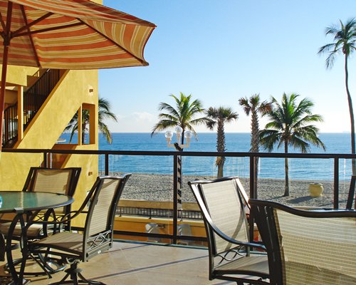 An outdoor dining area with two tables alongside the ocean.