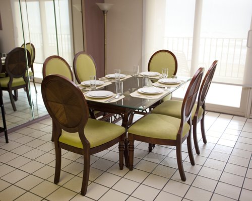 A well furnished dining area with a glass top table.