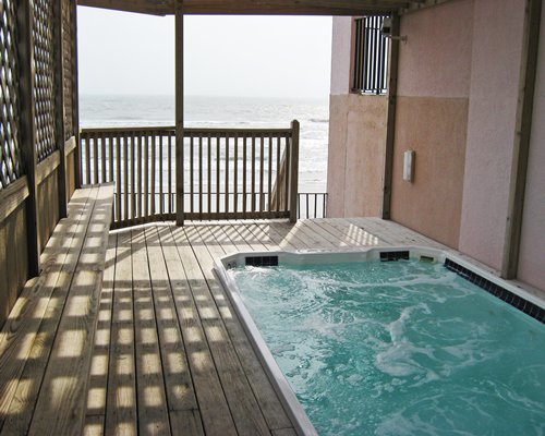 A hot tub in a balcony facing the ocean.