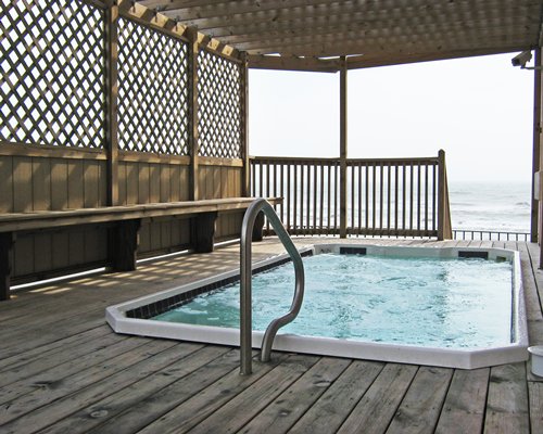 A hot tub in a balcony facing the ocean.