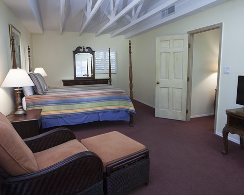 Furnished bedroom with vanity sofa and leg rest.