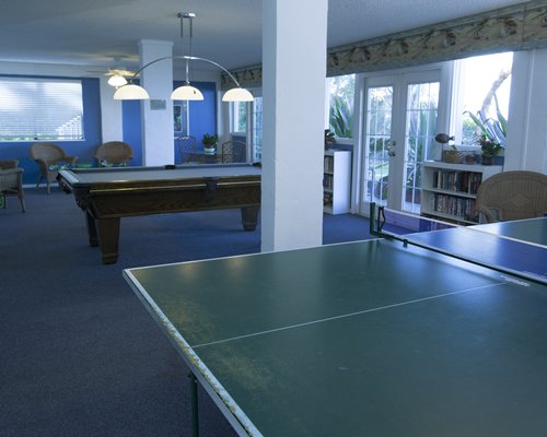 Indoor recreational room with ping pong and pool tables.