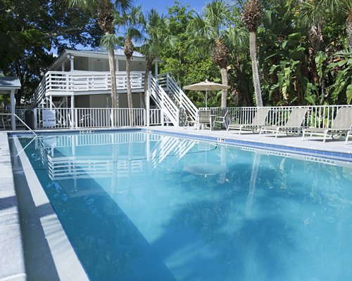 An outdoor swimming pool with chaise lounge chairs.
