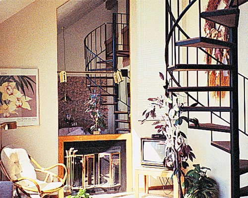 A well furnished living area with a stairway and a television.